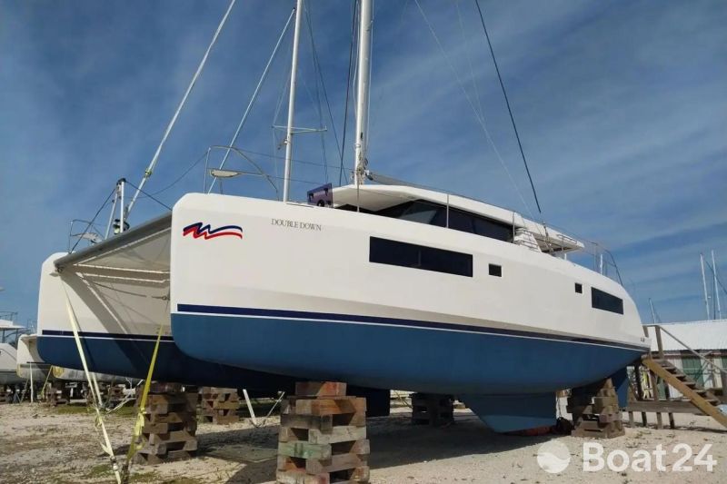 2020 Leopard 45 catamaran on land, supported by blocks, under a clear blue sky.