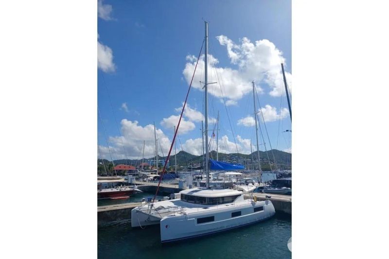 2020 Lagoon 46 catamaran docked in a sunny marina with blue skies.