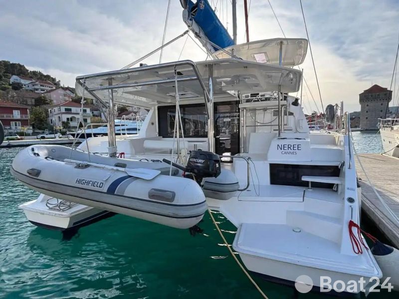 2019 Leopard 40 catamaran docked with inflatable dinghy, in a scenic marina setting.