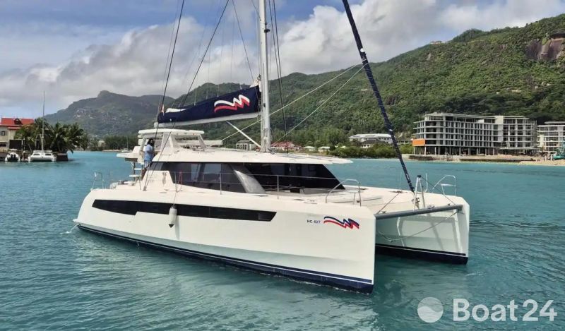 2020 Leopard 50 catamaran sailing in tropical waters with lush green mountains in the background.