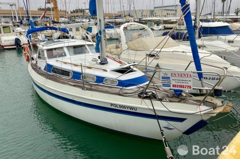 Sailboat Mascot 28, 1986 model, docked at marina, for sale sign visible.