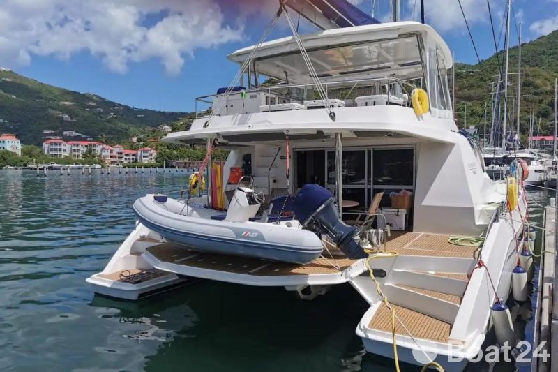 Luxury Leopard 58 yacht docked with inflatable boat, scenic marina backdrop.