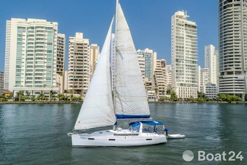 2013 Beneteau Oceanis 41 sailboat cruising near urban skyline on a sunny day.