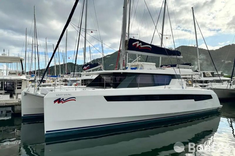 2021 Leopard 50 catamaran docked in marina, surrounded by other sailboats, under cloudy sky.