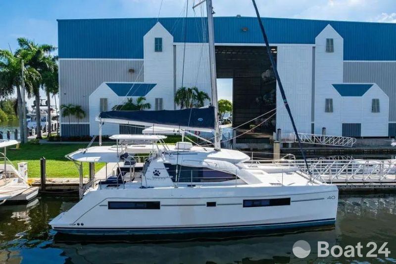 2016 Leopard 40 catamaran docked near a large blue and white building.