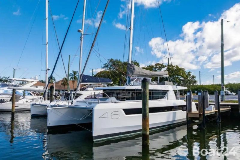 2025 Leopard 46 catamaran docked at marina under clear blue sky.