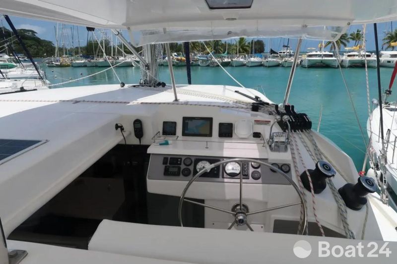 Cockpit of 2019 Leopard 40 catamaran in marina, featuring steering wheel and navigation equipment.