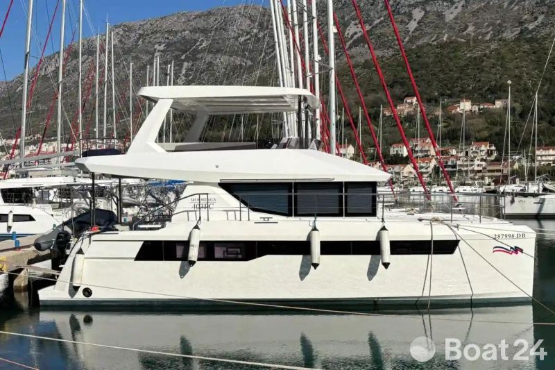 2024 Leopard 40 Powercat yacht docked in a marina with mountainous backdrop.