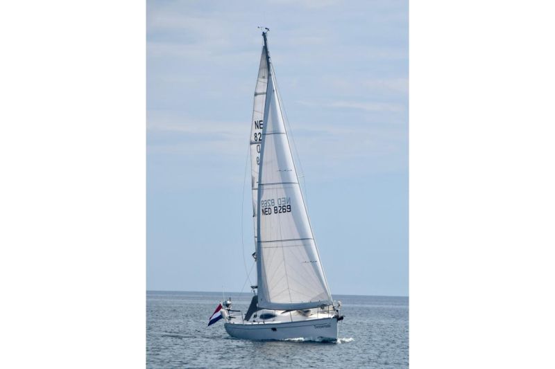 Sailboat "Feeling 32 DI" from 2010 sailing on calm waters under a clear sky.