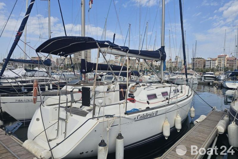 2008 Dufour 325 Grand Large sailboat docked in a marina, surrounded by other boats.