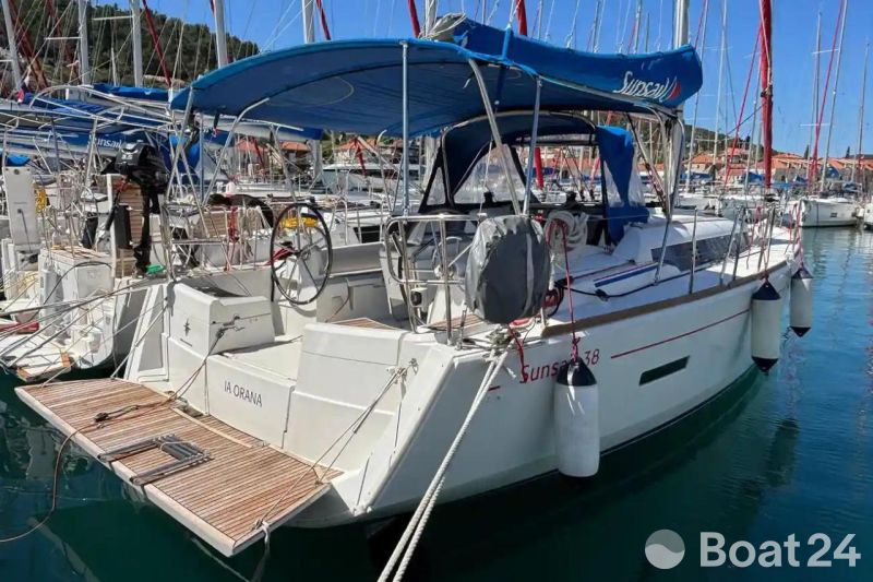 2020 Jeanneau Sun Odyssey 389 sailboat docked in a marina, featuring a blue canopy.