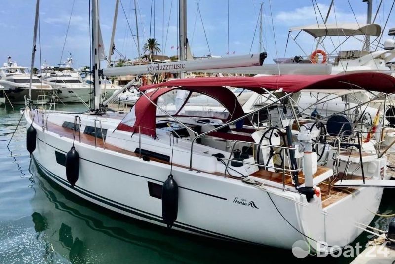 2019 Hanse 508 yacht docked in marina with red canopy and sleek design.