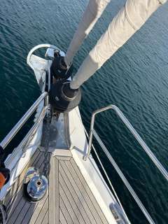 Bow of 2022 Hanse 510 yacht with sails, on calm water.