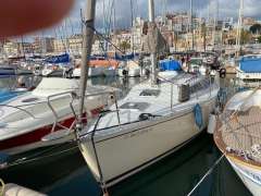 Sailboat docked in marina, Feeling 286 model, 1988, surrounded by other boats.