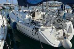 2005 Dufour 40 Performance sailboat docked in marina, featuring sleek design and blue canopy.