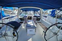 2019 Beneteau Oceanis 41.1 sailboat cockpit with dual steering wheels and blue canopy.