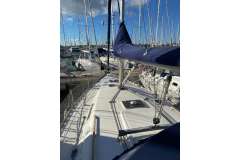 Dufour 36 Classic 2000 sailboat docked in marina, clear sky, multiple yachts in background.