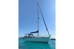 Sailboat Dufour 36 Classic 2000 on clear blue water under sunny sky.