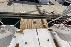 Jeanneau Sun Odyssey 509 yacht stern view with wooden deck, docked at marina.