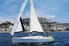 2005 Grand Soleil 40 sailboat cruising near coastal hillside town.