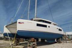 2020 Leopard 45 catamaran on land, supported by blocks, under a clear blue sky.