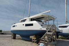 2020 Leopard 45 catamaran on dry dock with wooden stairs and clear sky.