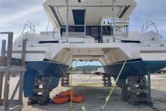 2020 Leopard 45 catamaran on dry dock, supported by wooden blocks, with visible hull and equipment.
