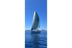 2018 Hanse 588 sailboat gliding on calm blue waters under clear skies.