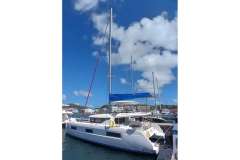 2020 Lagoon 46 catamaran docked at marina under clear blue sky.
