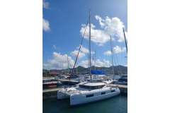 2020 Lagoon 46 catamaran docked in a sunny marina with blue skies.