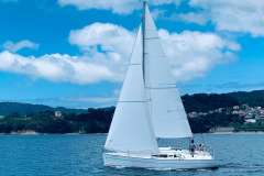2002 Jeanneau Sun Fast 32i sailing on a scenic coastal waterway.