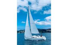 2002 Jeanneau Sun Fast 32i sailboat cruising on a sunny day with blue skies.