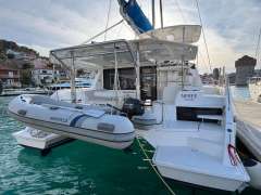 2019 Leopard 40 catamaran docked with inflatable dinghy, in a scenic marina setting.