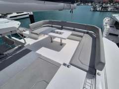 Spacious seating area on a 2020 Leopard 50 yacht, featuring a modern table and marina view.