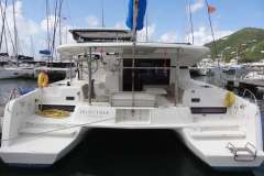 2020 Lagoon 42 catamaran docked in marina, rear view with clear sky.