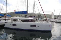 2020 Lagoon 42 catamaran docked in a marina, surrounded by other sailboats.