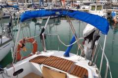 Sailboat deck with blue canopy, life preserver, and wooden seating, Mascot 28, 1986 model.