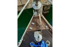 Bow of 1986 Mascot 28 sailboat with anchor chain and wooden deck.