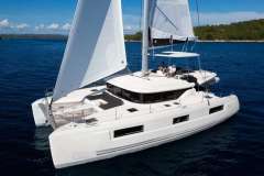 2022 Lagoon 46 catamaran sailing on blue ocean with white sails.