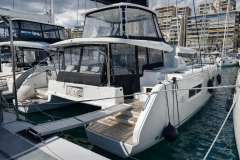 2022 Lagoon 46 catamaran docked in a marina, featuring modern design and spacious deck.
