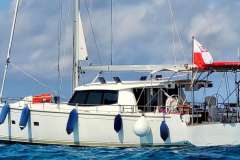 Sailing yacht Moody 45 DS 2020 on calm sea with blue fenders and flag.