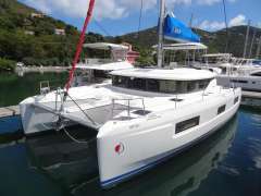 2020 Lagoon 46 catamaran docked in a scenic marina with lush hills.