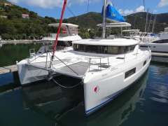 2020 Lagoon 46 catamaran docked in a scenic marina with lush hills.