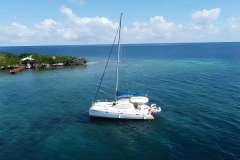 Sailing catamaran Leopard 38, 2008 model, anchored near tropical island in clear blue waters.