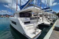 Leopard 45 catamaran docked at marina, 2021 model, sunny day, blue sky.