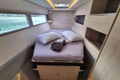 Luxurious cabin interior of 2021 Leopard 45 yacht with cozy bed and scenic windows.