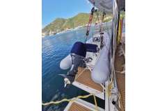 Leopard 58 yacht with dinghy, docked by scenic waterfront, 2020 model.