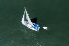 Aerial view of 2013 Beneteau Oceanis 41 sailboat with dinghy on calm water.