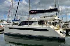 Luxury Leopard 50 catamaran yacht docked in marina, 2021 model, under cloudy sky.