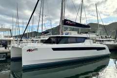 2021 Leopard 50 catamaran docked in marina, surrounded by other sailboats, under cloudy sky.